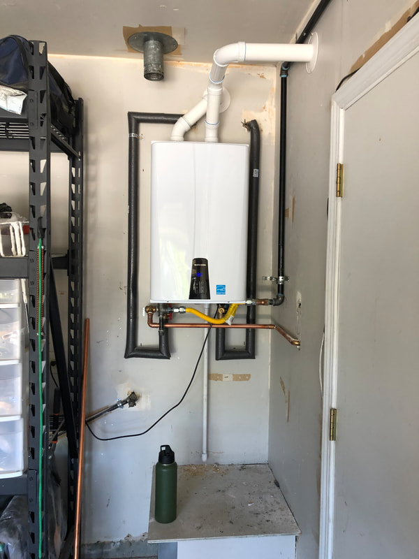 a tankless water heater that was installed in the corner of a garage. 